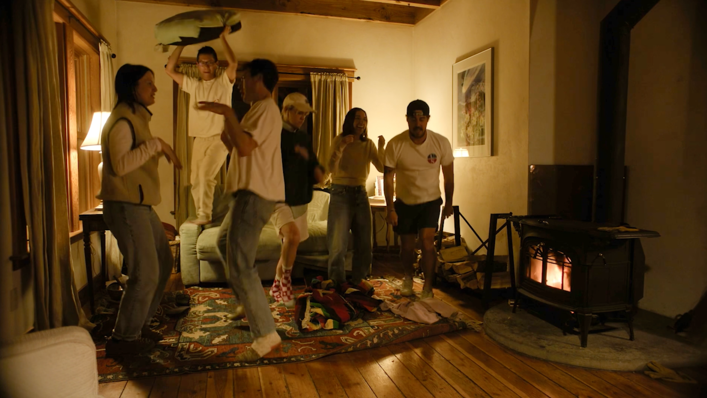 The crew dancing by the wood stove inside the Meadow House