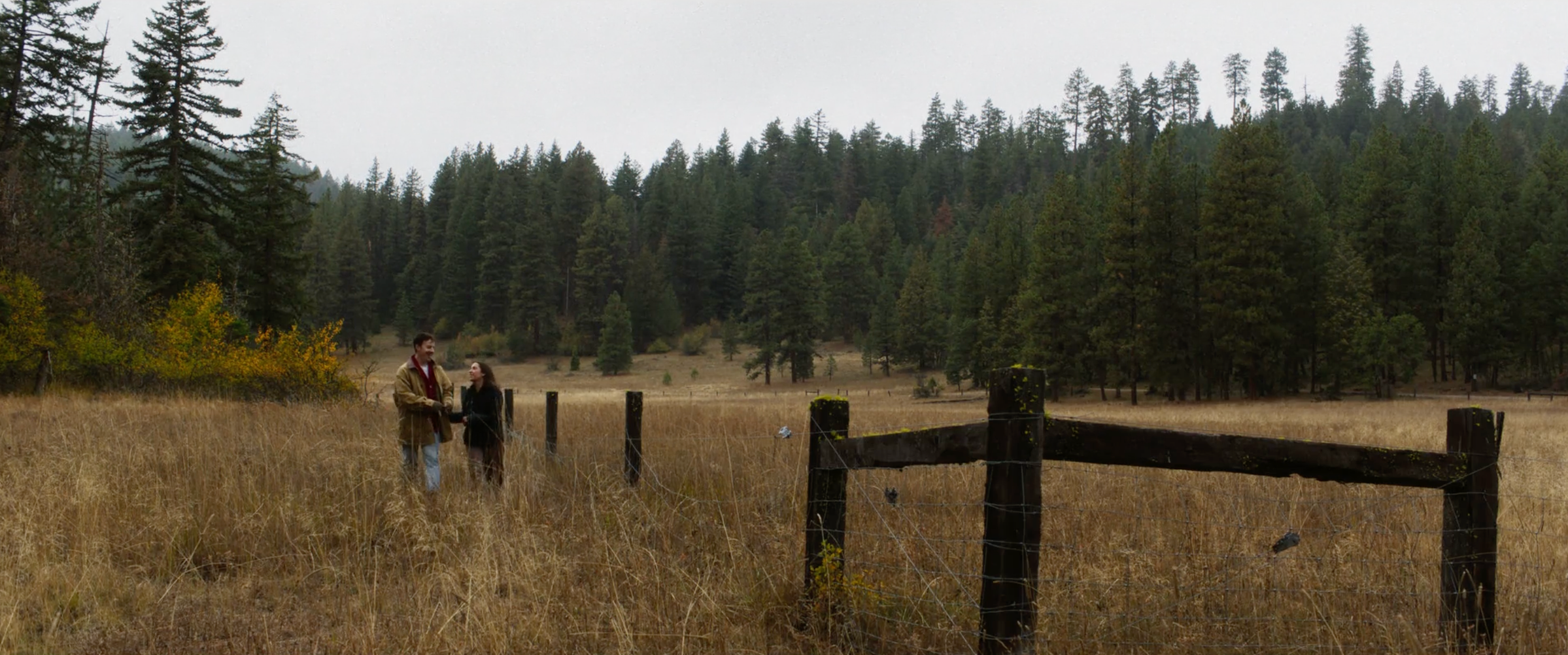 Margot and Julian at a fence line on the Oregon meadow